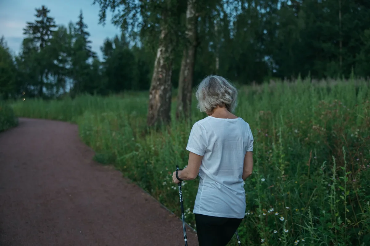A person walking along a path through green fields