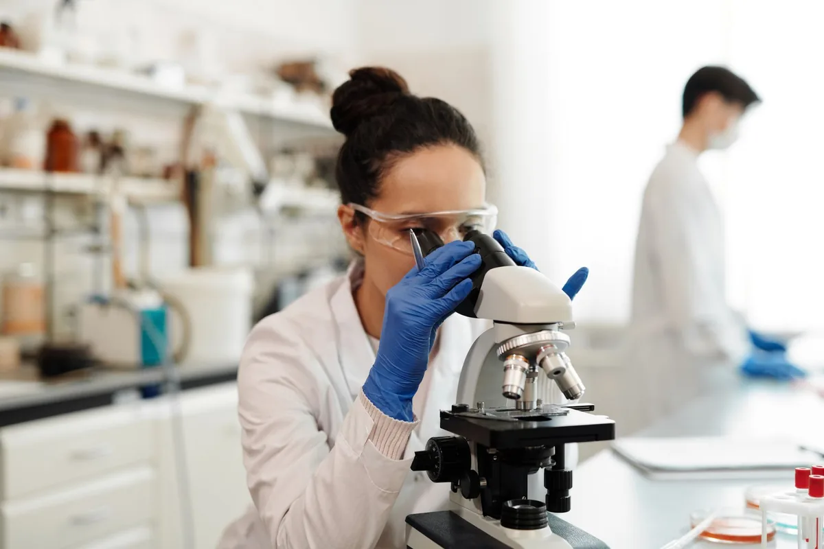 A researcher using a microscope in a laboratory