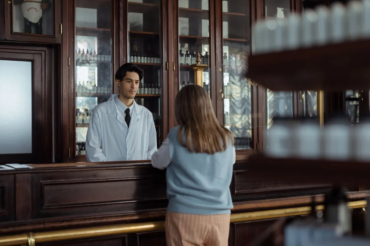 A pharmacist speaking with a customer at the pharmacy counter